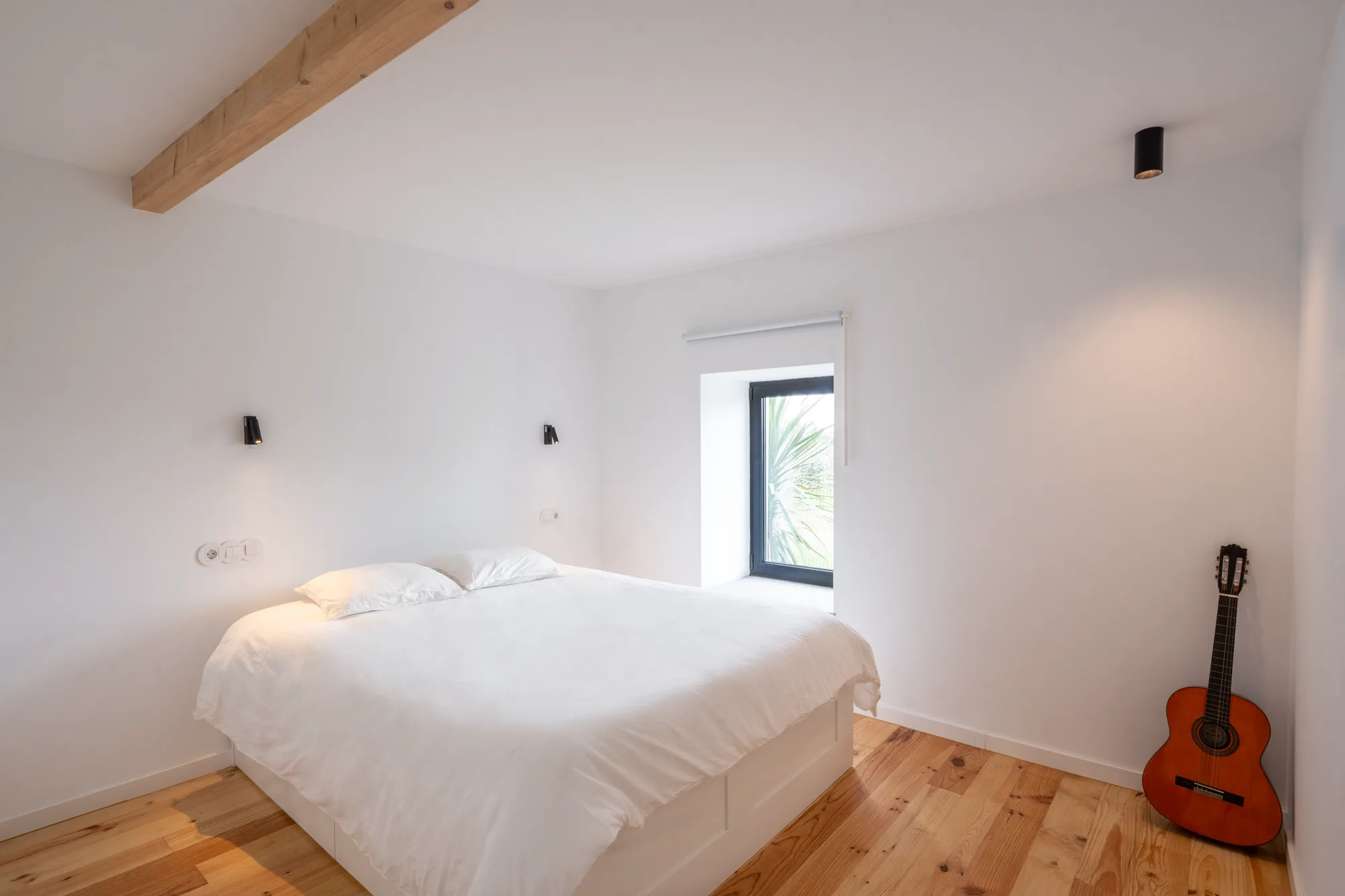 Guest room with simple natural styling and acoustic guitar