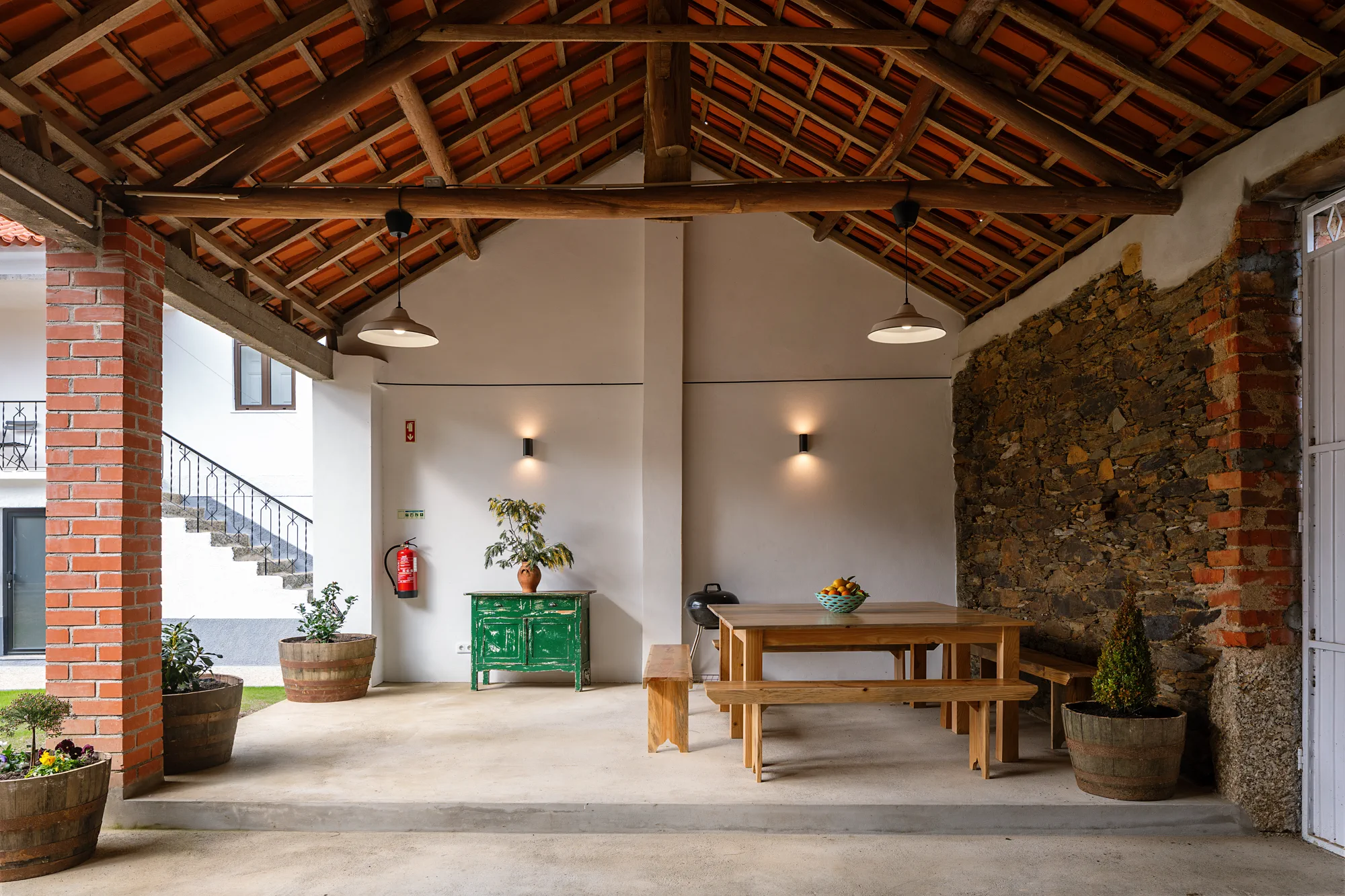 Covered outdoor dining area beside the farmhouse courtyard